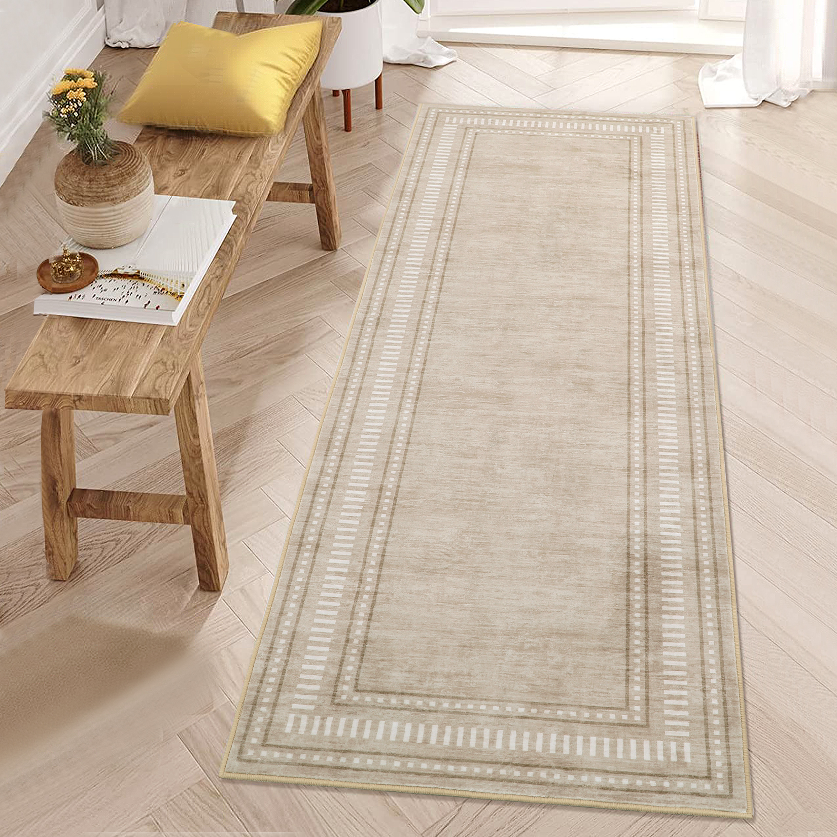 Beige washable area rug with modern border design laid flat on a light wood floor